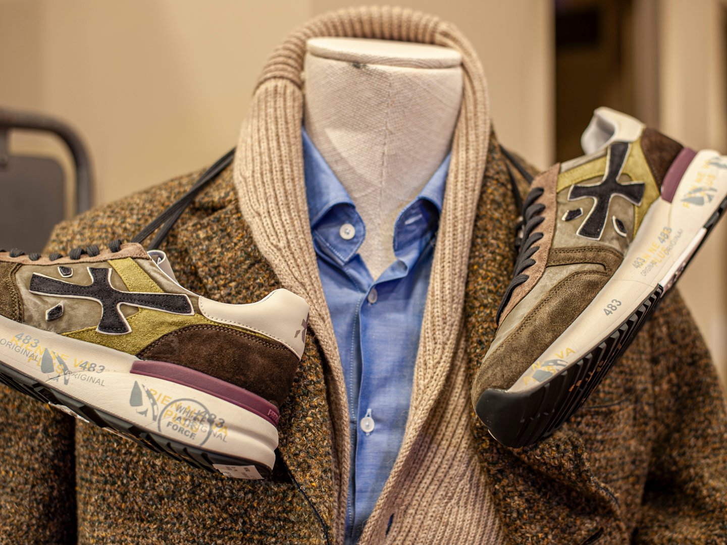 Zapatillas blancas y sudadera gris en conjunto casual masculino.