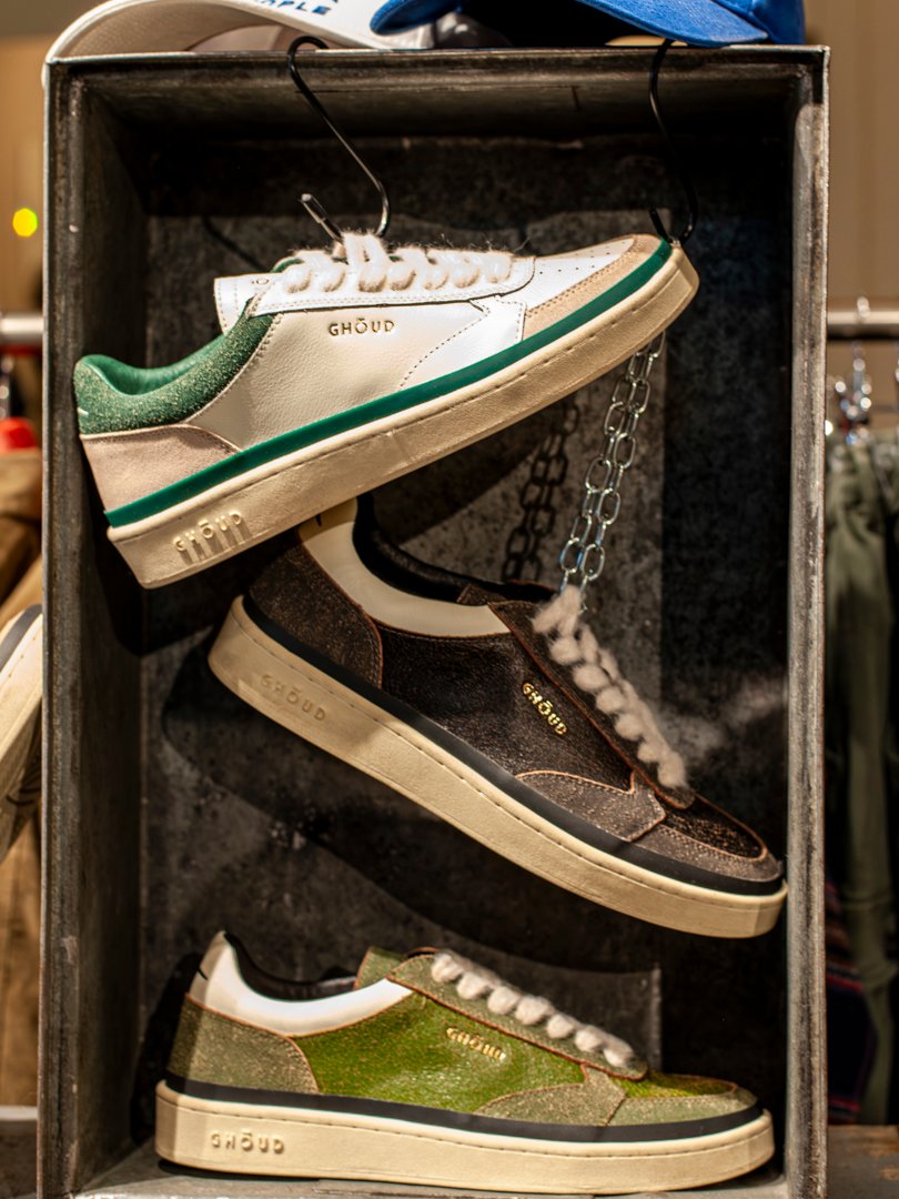 Zapatillas blancas y sudadera gris en conjunto casual masculino.