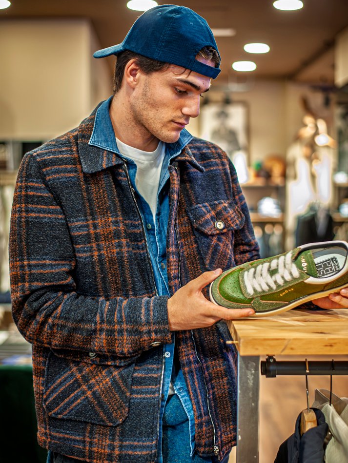 Diseñador bilbaíno ajustando prenda exclusiva en modelo masculino.