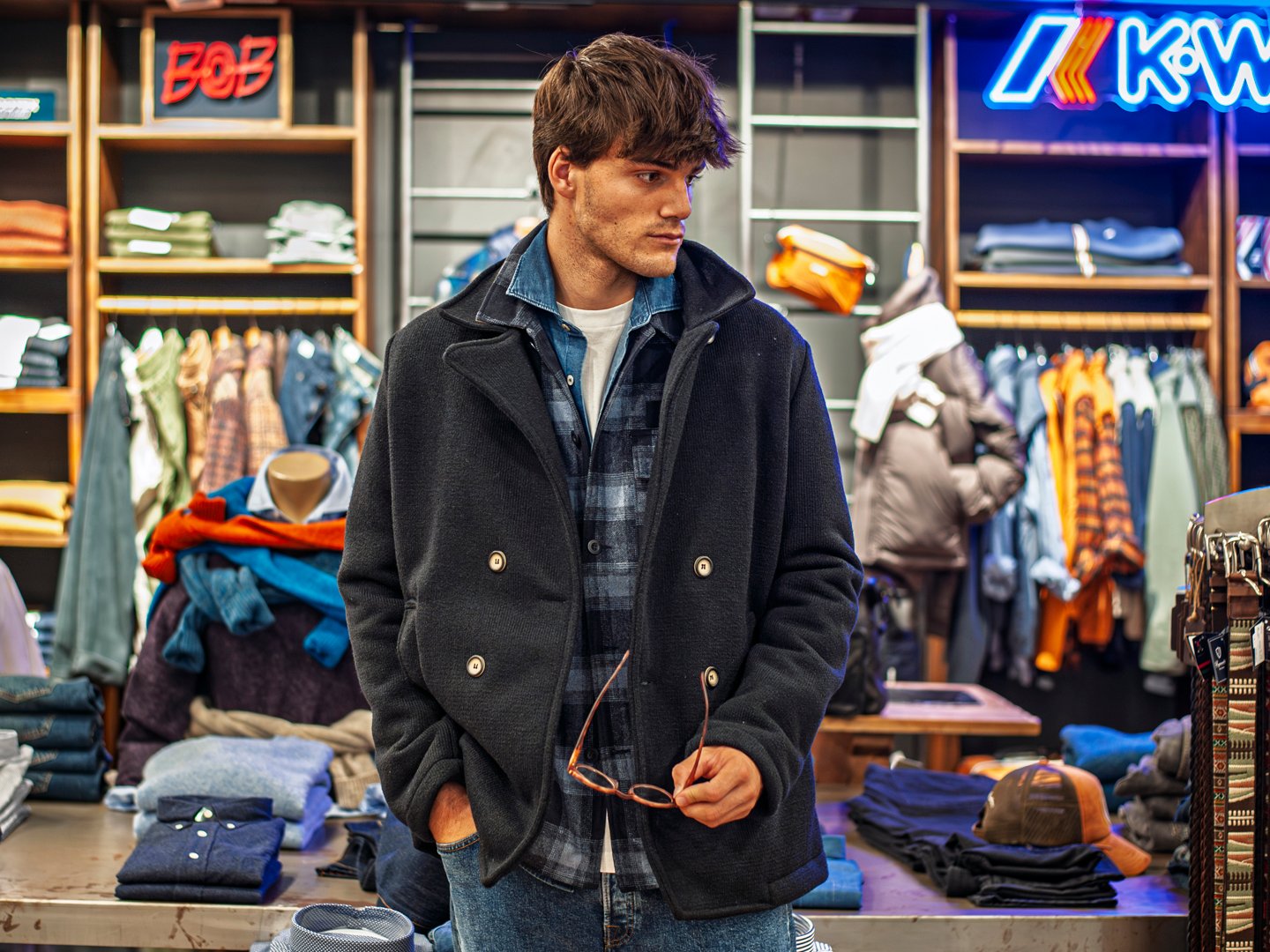 Hombre con abrigo largo y bufanda caminando por las calles del Ensanche.