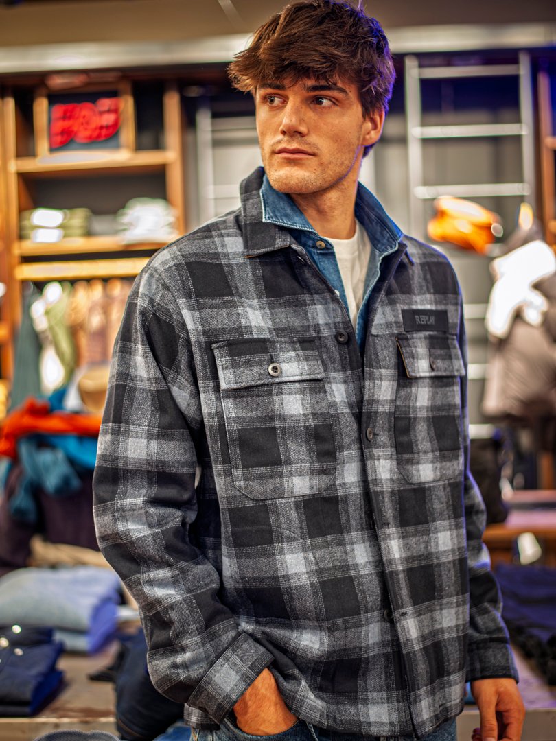 Detalle de prendas de la nueva temporada expuestas en perchas de madera.