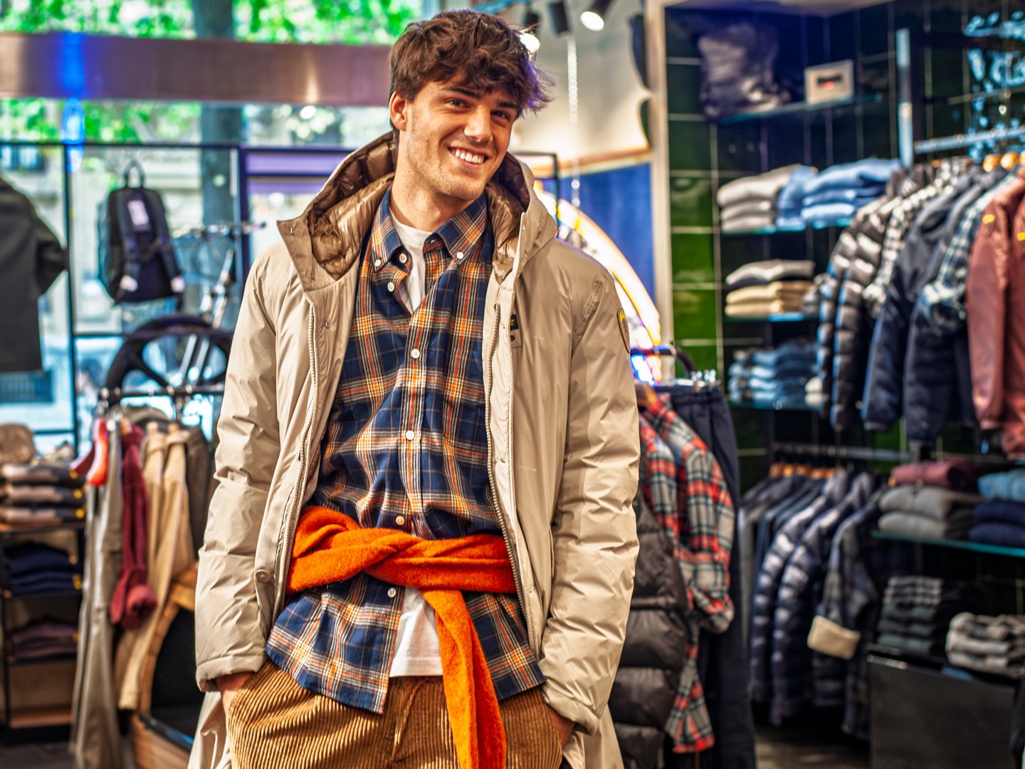 Ropa invernal masculina doblada en mesa de exposición de tienda local.